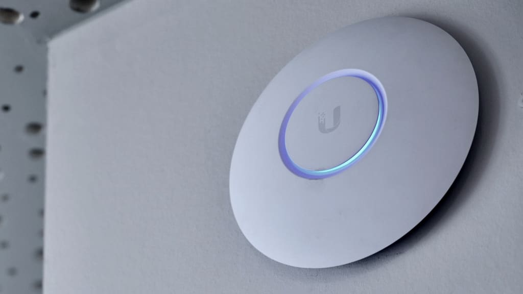 Access point Wi-Fi Ubiquiti UniFi installato a soffitto, con l'anello luminoso acceso